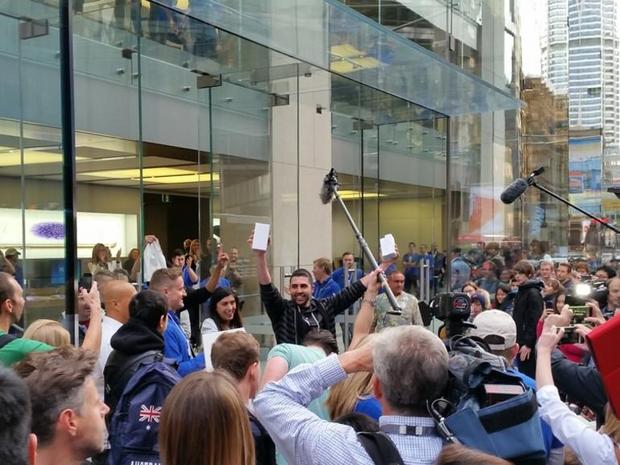 　10日近く列に並んだ後、シドニーのApple Storeにおける最初の購入者がiPhone 6を手にして店外に姿を現す。