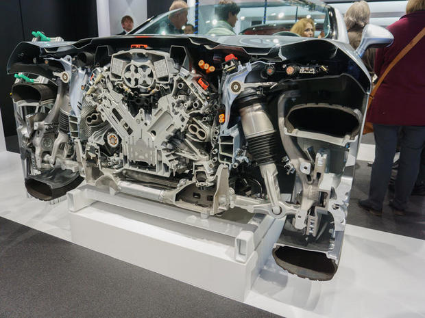 　最後に紹介する展示部品は、V6スーパーチャージャー搭載のハイブリッドモデル「Porsche Panamera」のエンジンコンパートメントだ。エンジンシリンダーの上に搭載されたスーパーチャージャーと、ハイブリッドシステムに動力を伝える明るいオレンジ色のケーブルが見える。