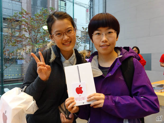 　どのアップルストアの店舗でも、金額にかかわらず購入者には12月1日限定でこの赤いステッカーがプレゼントされる。iPad miniを購入した女性たち。中国から訪れたという。
