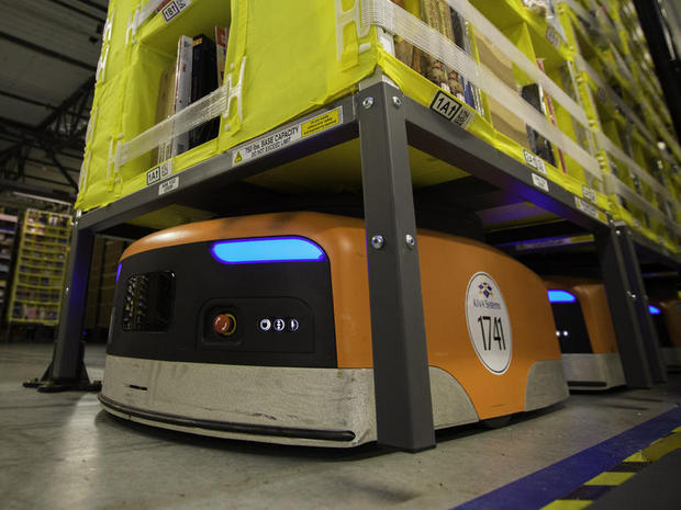 　カリフォルニア州トレーシーにある120万平方フィート（約11万1500平方m）の巨大な倉庫で、Amazonは3000体以上のロボットの力を借りて、顧客の注文を処理している。

　写真の「Kiva」ロボットは、真四角でずんぐりとした実用的な機械だ。Kivaは最大750ポンド（約340.2kg）を持ち上げることができるので、注文品を梱包する従業員のところまで棚を運ぶことが可能だ。

関連記事：アマゾン、「Kiva」ロボットなど活用する最新配送センターを公開
