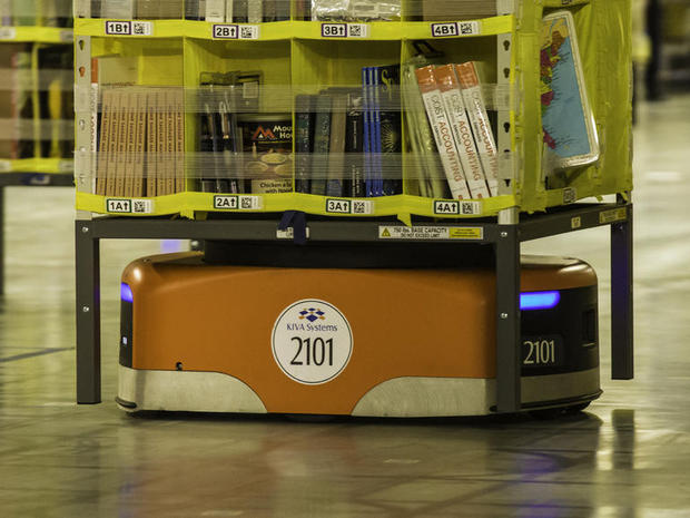 　Kivaロボットが製品の収納された棚を持ち上げ、倉庫内を動き回って、注文を処理する「ピッキングステーション」の1つまで移動する。