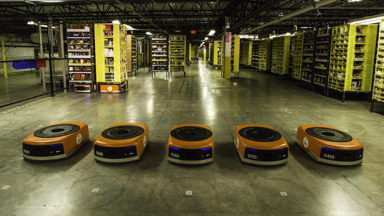 カリフォルニア州トレーシーにあるAmazonのフルフィルメントセンターでテスト走行をするため一列に並んだ5体のKivaロボット