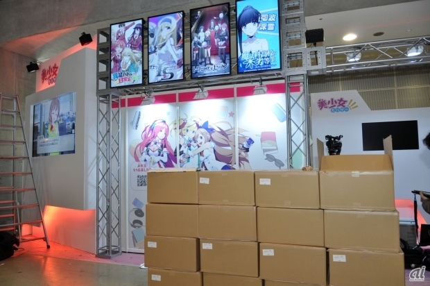 　ディー・エヌ・エー（DeNA）は2014年12月28日から3日間、東京国際展示場において開催されたコミックマーケット87（コミケ87）に企業ブース出展を行った。

　同社の企業ブース出展はコミケ85、コミケ86に続いて3度目。今回はブース名を「美少女Mobage!!!」として出展。配布物のほかに、ブース内ステージからニコニコ生放送「ハッカちゃんねる　～冬コミすぺしゃる～」の配信を行った。そしてこの番組には筆者も登壇した。ここではブースや番組の模様をお伝えする。

　写真は準備段階の様子で配布物の段ボールが山と積まれている。