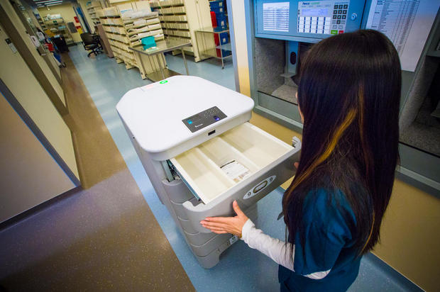 個々の患者への医薬品運搬

　UCSFメディカルセンターの薬局助手Jeanette Lamさんが指紋認証システムを使って、ロボットの個別のコンパートメントにアクセスしている。
