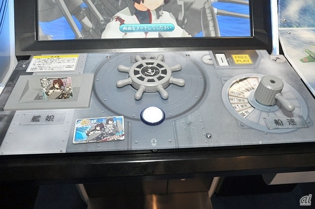 筐体左側には艦娘トレカを読み込むポケット、中央には操舵輪に発令ボタン、右側に船速レバーが装備されている。