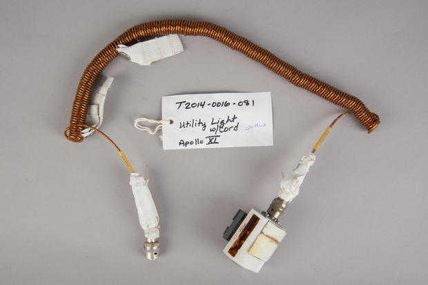 ユーティリティライト（多用途照明）とクランプ

　Apollo 11号ミッションで使われた、銅製の蛇のようなこの器具はユーティリティライトで、ブラケットアセンブリが取り付けられている。設置が困難な場所にライトを取り付けるために、マジックテープが使われた。