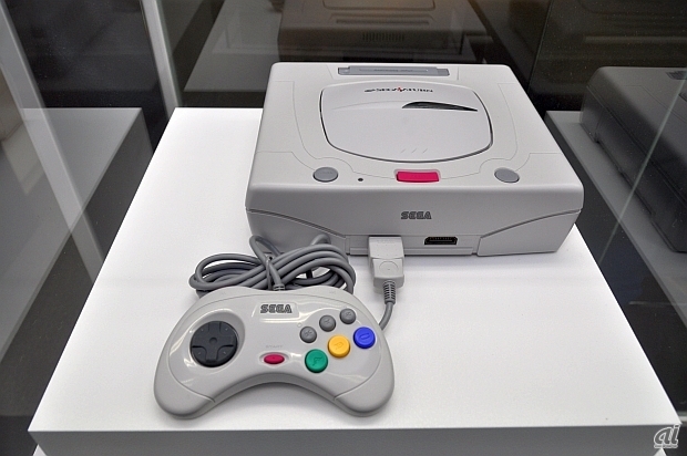 　1994年に発売。CDドライブに2つの32ビットCPUを搭載。
「64ビット級」をうたい文句に3DCGゲームや高解像度の2Dゲームなどを展開し、国内で最も売れたセガハードとなっている。なお展示されているのは、1996年にデザインを一新して発売された白色の本体となっている。