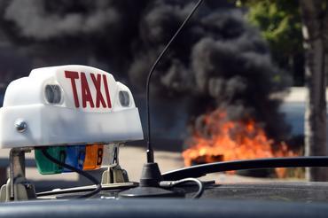 タクシー運転手らは先週、Uberに抗議するデモで道路を封鎖し、タイヤに火を付けた。Uberは抗議対象となっていたサービスを停止した。
