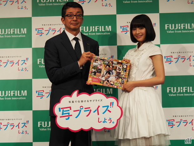 富士フイルム 宣伝部長の松本孝司氏とCMキャラクターの広瀬すずさん。中央の写真は、モデル仲間からサプライズでプレゼントされたもの