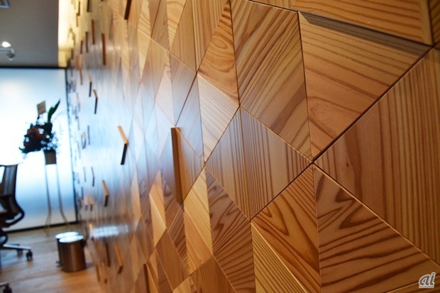 　壁は木目調で、こちらも杉を使用。「焼杉板」というもので、杉に焼き目を入れて、その焼き加減によって3種類のグラデーションを施しているそうです。組み合わせた板はすべて三角形。日本伝統の技術である「組子（くみこ）」を用いて仕上げたといいます。