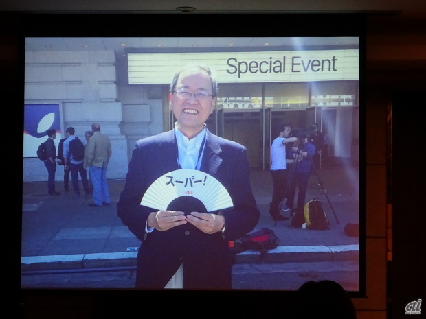 アップルのイベント会場前で「スーパー」の文字が入った扇子を持つKDDI代表取締役社長の田中孝司氏