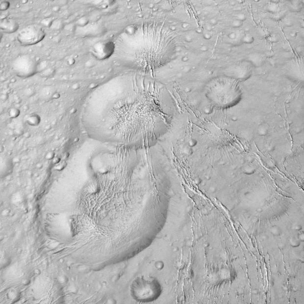 月面のスノーマン

　一列に並んだ3個のクレーターは、まるで土星の衛星エンケラドスの地表に描かれたスノーマンのように見える。NASAのCassiniミッションが撮影したこの画像は、衛星の北極域付近にさらに接近する途中で6000マイル（約1万km）上空から撮影したもの。