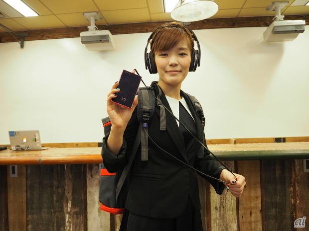 製品を身に着けたUPQ代表取締役の中澤優子氏。手にしているのは新たにリリースする5インチスマホ「UPQ Phone A02」だ