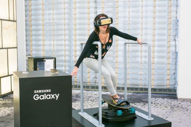 　動くスケートボードに乗ってGear VRをテストした。写っているのは米CNETの編集者Jessica Dolcourtだ。