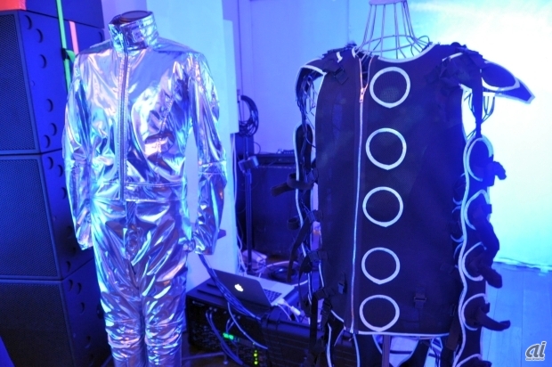 　こちらがシナスタジア・スーツ。右にある黒色のスーツが振動素子が搭載されたもの。左にある銀色のスーツは、振動に連動して発光するLEDが搭載。この2着をあわせて着用するものとなっているが、体験会では振動素子を搭載したもののみを着用する形となっている。