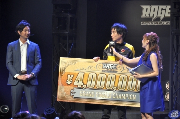 　RAGEの運営統括を務めるCyberZの大友真吾氏（左）から、優勝賞金400万円が贈られた。