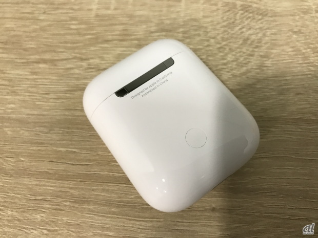 　AirPodsの背面。小さく、「Designed by Apple in California」の文字に加え、「Assembled in china」の文字も書かれている。下に見えるのはセットアップボタンだ。
