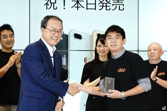 　2年連続で最初の予約購入者となったカワダさん。iPhone 8のスペースグレーモデルが田中社長から手渡された。