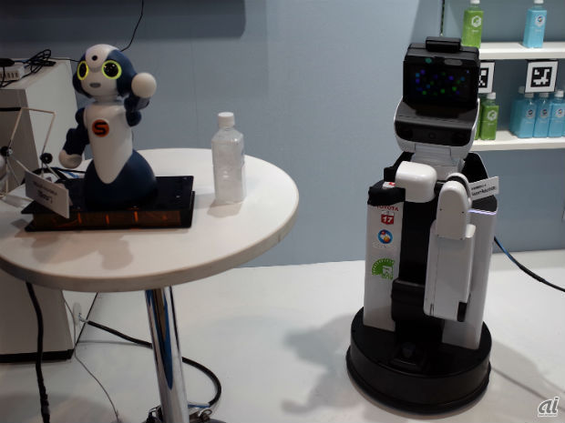 　NTTグループでは、「おしゃべり」が得意なロボットとモノを「取ってこられる」ロボットを組み合わせて、接客サービスのデモをしていた。おしゃべりが得意なロボットがお客様の要望を聞き、モノと取ってこられるロボットが棚から該当の商品をもってくる。NTT研究所で開発されたヒト×モノ×ロボットをつなぐビジュアルプログラミングツール「R-env：連舞」を使用しており、さまざまなロボット、家電、センサを連携、制御できるという。