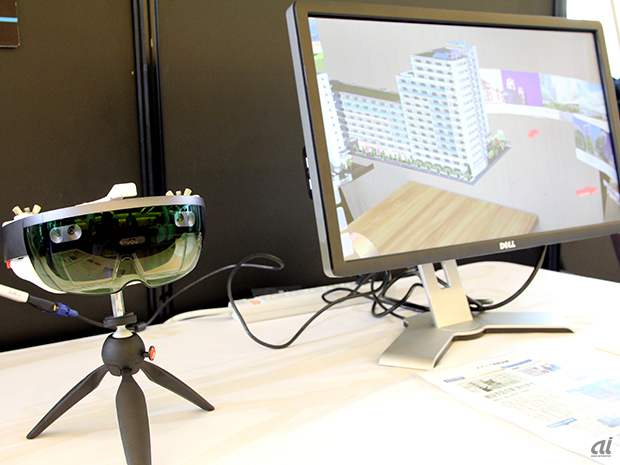 　ネクストスケープは、マイクロソフトのホログラフィックコンピュータ「HoloLens（ホロレンズ）」を活用したVR物件ビューアを展示。透過性のあるメガネ型端末というホロレンズの特性を活かして、新築物件予定地で建物完成イメージを体験したり、部屋の中で建物の全体像を視聴したりとさまざまな活用ができるという。すでに野村不動産が新築物件の販売促進のツールとして採用しているとのこと。