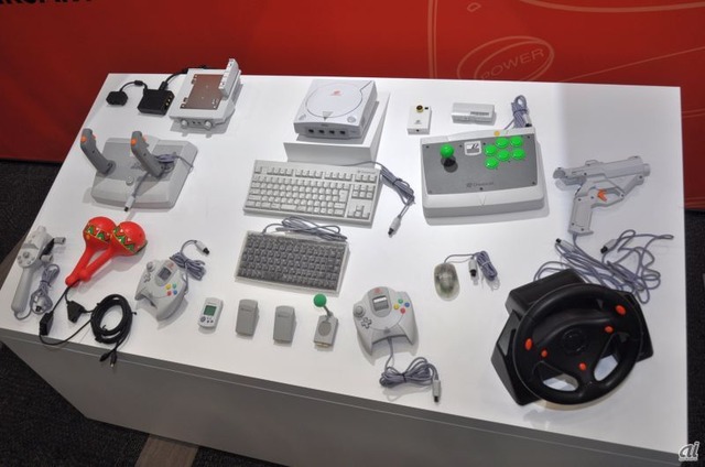 　ドリームキャスト本体と周辺機器の数々。リズムゲーム「サンバDEアミーゴ」用のマラカスコントローラ DCなども展示されている。