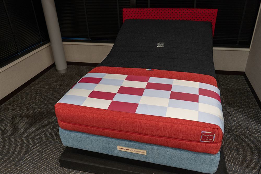 フランスベッドと共同で開発した「睡眠モニタリング機能付きマットレス（ルーパーRP-5000SE）」。KDDIが販売するスマートフォン「INFOBAR」をイメージしたデザインになっている