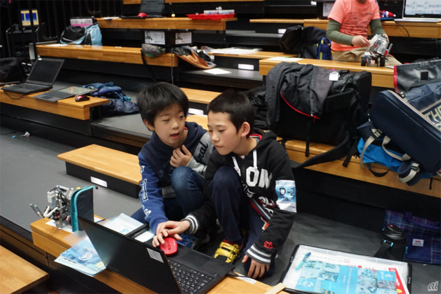 　栄光ロボットアカデミー横浜校の木村匡吾さん（10歳）と佐藤輝さん（9歳）。「1回目の自分たちのパフォーマンスは点数をつけるなら70点くらい。後半戦頑張りたい。ライバルは東京スカイツリーチーム。負けたくない」と話す。話し合ってロボットのプログラムをPCで微調整しているところ。