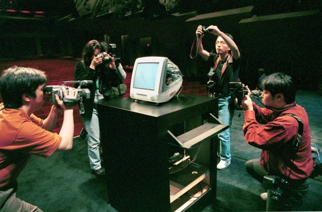 　Appleの共同創業者で当時暫定CEOだったSteve Jobs氏が、1999年10月5日にカリフォルニア州クパチーノで発表した新しい「iMac DV Special Edition」を写真や動画に収めるメディアの様子。当時撮影を試みる報道陣の数はおびただしいもので、巻き込まれれば道を見失うほどだった。