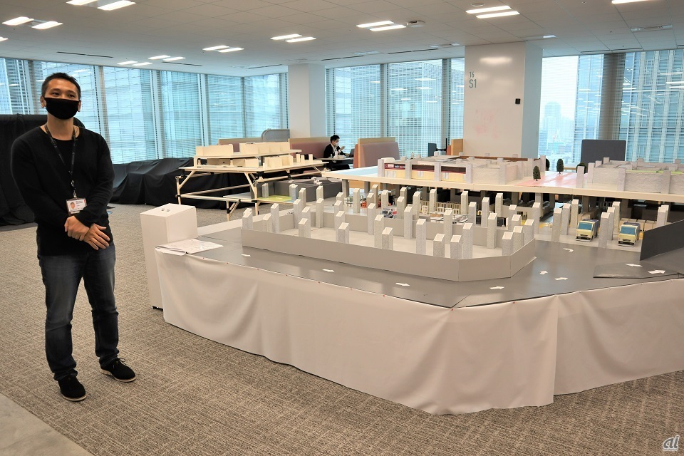 Logistics Managerの政田氏とオフィス内に構築した物流システムの模型