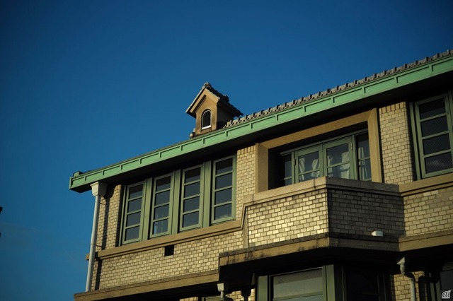 緑色の瓦屋根と外壁のタイルが特徴的な外観