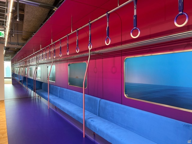 　日本の通勤電車にインスピレーションを受けたという「映え」スペース。本物そっくりの椅子と吊り革が並ぶ。窓は液晶ディスプレイで実際に景色が移り変わる。