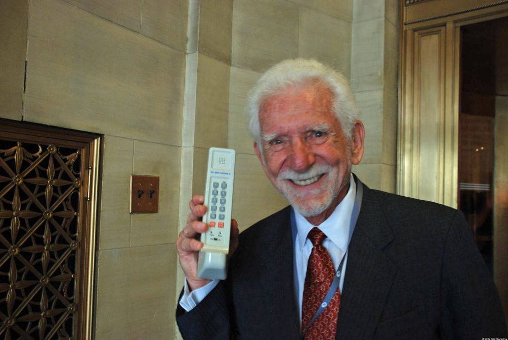 旧式の携帯電話を手にするMartin Cooper氏