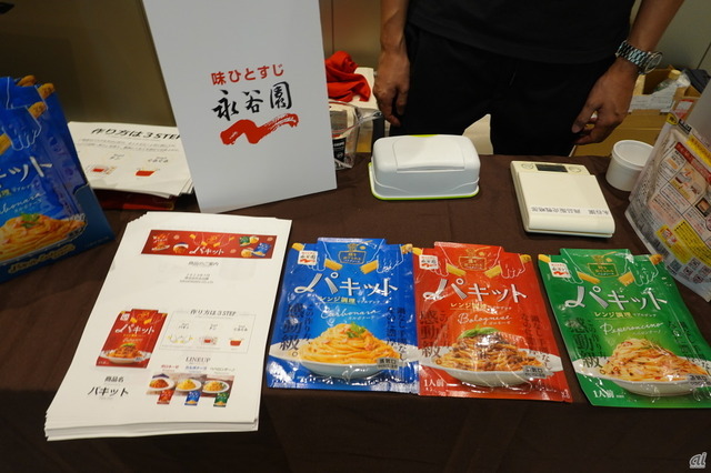 　永谷園は、パスタを用意すれば、電子レンジだけでパスタが仕上がる「パキット」シリーズを展示した。3月から全国で発売している。フライパン1つだけで仕上げる「ワンパンパスタ」が人気だが、パキットシリーズはソースが入った袋の中に水と折ったパスタを入れて電子レンジにかけるだけで仕上がるのが特長。製品によって調理時間は若干異なるが、電子レンジ加熱＋蒸らしの約13分で完成する。