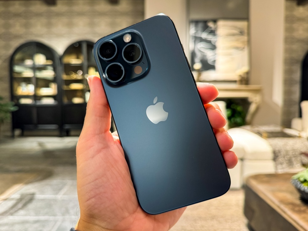 iPhone 15 Pro Maxのメインカメラで撮影した、ブルーチタニウム仕上げのiPhone 15 Pro。インテリアショップの店内で撮ったものだが、肌色の再現度が高く、深度も正確に認識できている。