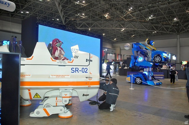 　主催者イベントとして、ひときわ注目を集めていたのは「巨大ロボット実演展示」。ジェットコースターなどの遊戯機械を手がける三精テクノロジーズが開発した、乗用人型変形ロボット「SR-01」と四足歩行ライド「SR-02」のデモが実施。