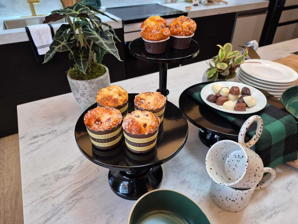 A photo of a kitchen counter lined with muffins and chocolates