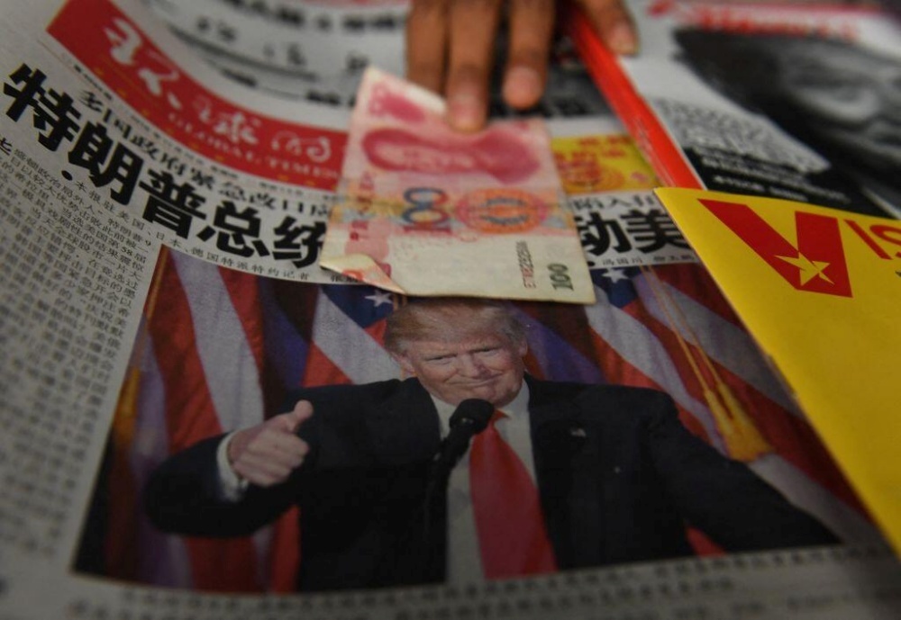 Trump氏の写真が掲載された中国の新聞と、中国の紙幣<br>提供：Greg Baker/Getty Images