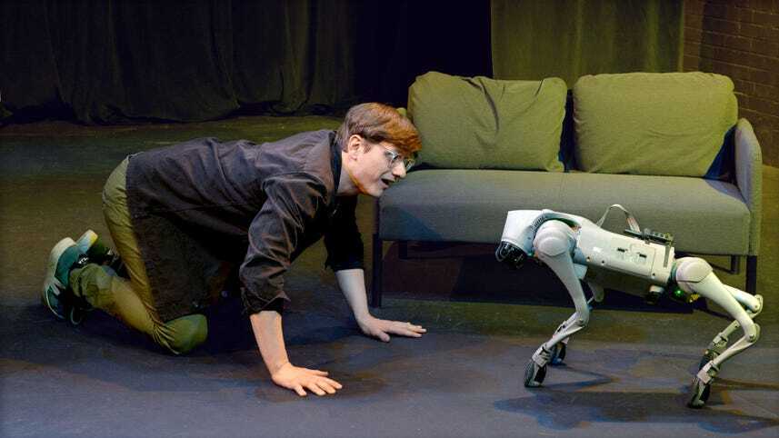 かがんだ俳優と向き合うロボット犬