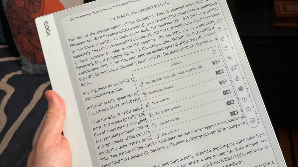 BOOX Note Maxを手に持っているところ、画面には書籍のページとフローティングメニュー
