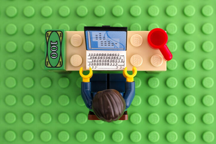 デスク上でPCを操作するレゴの人物