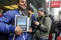 iPadを抱えて満面の笑みを浮かべながらサンフランシスコのApple Storeから出てきた男性