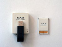 W-SIM対応通信アダプタ「DD」（左）とW-SIM（右）。W-SIMのサイズはSDメモリーカードを一回り大きくした程度しかない